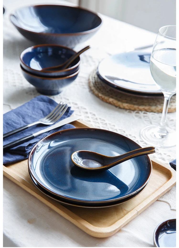 Deep blue ceramic dinnerware set by MC THE BLACK DIAMOND, includes plates and bowls for elegant table setting.