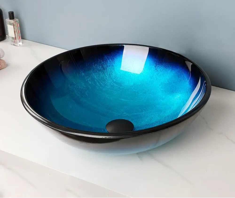 MC THE BLACK DIAMOND ZAPPO tempered glass bathroom vessel sink with black waterfall faucet, blue oval above-counter basin.