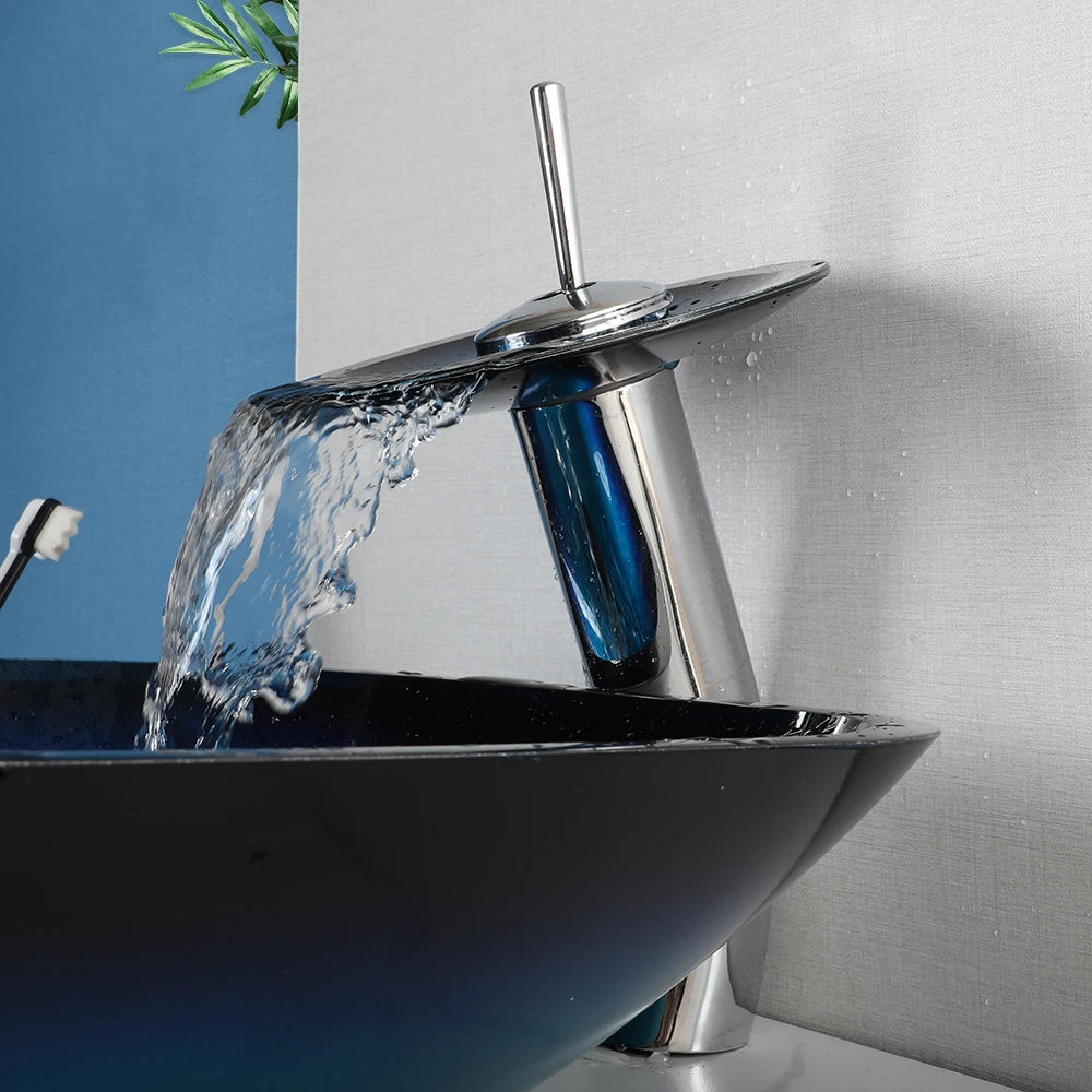 MC THE BLACK DIAMOND ZAPPO tempered glass vessel sink with black waterfall faucet and oval blue basin, above counter bathroom basin.