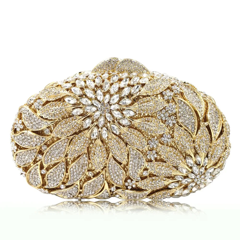Gold metal leaves evening clutch bag by MC THE BLACK DIAMOND featuring white crystal accents and a mini heart design for women.