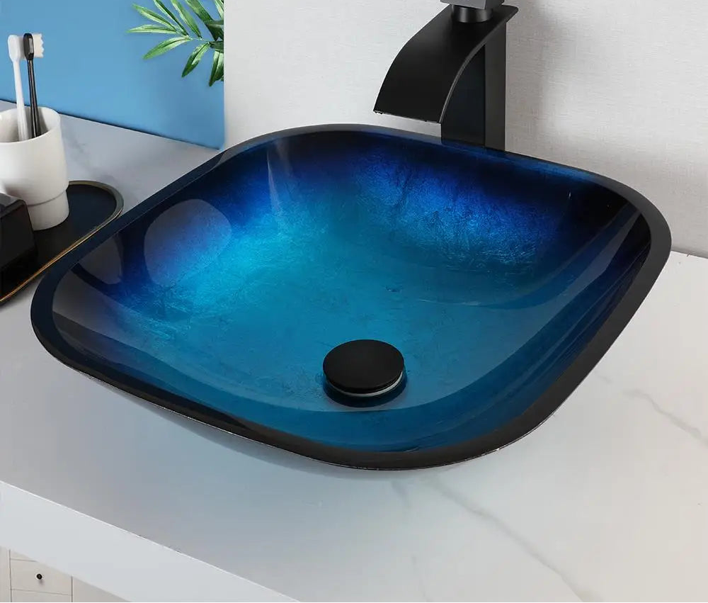 MC THE BLACK DIAMOND ZAPPO tempered glass bathroom vessel sink with black waterfall faucet, oval blue basin above counter.