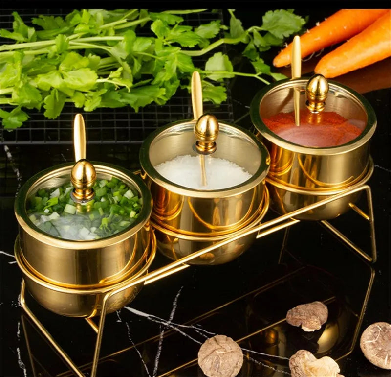 MC THE BLACK DIAMOND gold 304 seasoning box with glass cap, spoon, and salt jar for kitchen spice storage and sauce serving.