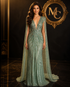 Sharon Said luxury Dubai sage green evening dress with cape, fuchsia crystal accents, gold details, worn by a woman at a wedding or party.