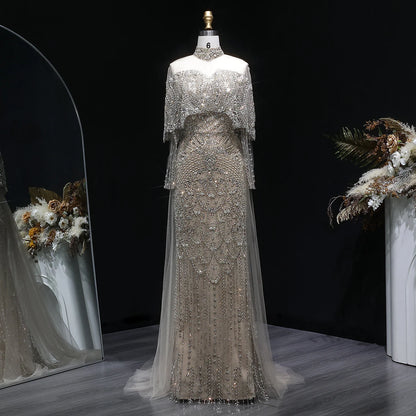 Beaded grey Arabic evening dress by MC THE BLACK DIAMOND featuring intricate beadwork and elegant flowing fabric.
