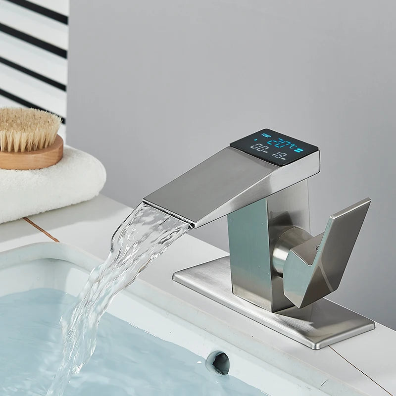 Smart digital display basin sink faucet with LED temperature indicator, waterfall spout, hot and cold water controls, in modern bathroom decor.