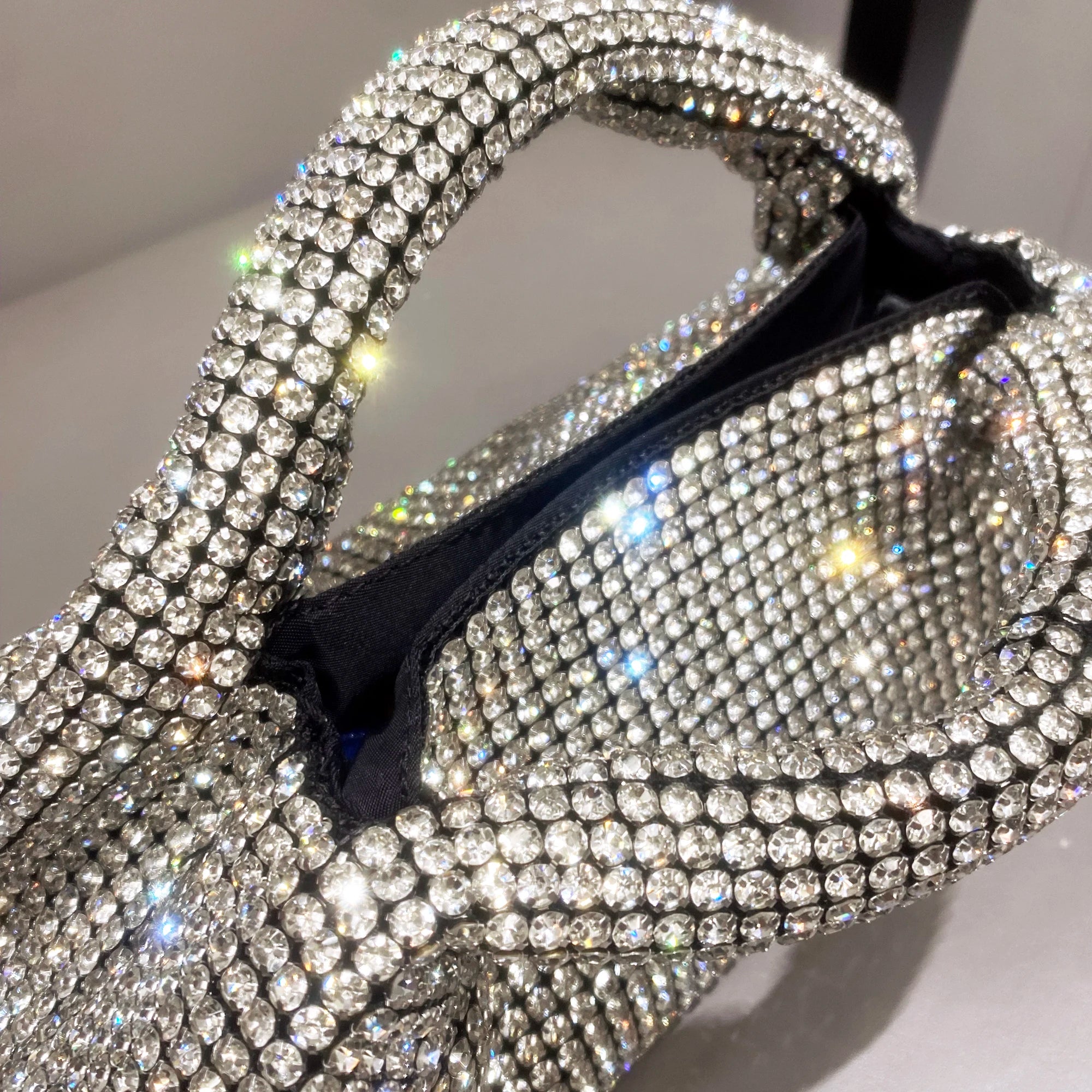 Shiny crystal clutch purse by MC THE BLACK DIAMOND, handmade rhinestone evening handbag with a bucket shoulder bag design.
