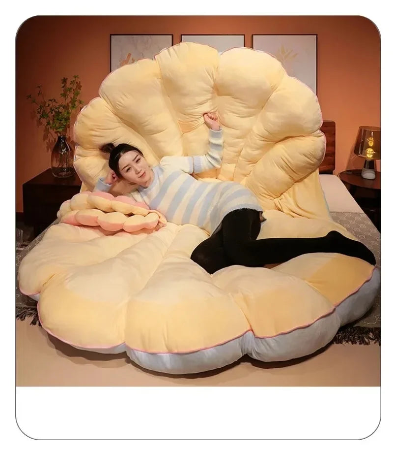 Large clam-shaped plush cushion from MC The Black Diamond, designed as a giant seashell sofa pillow for kids' beds.
