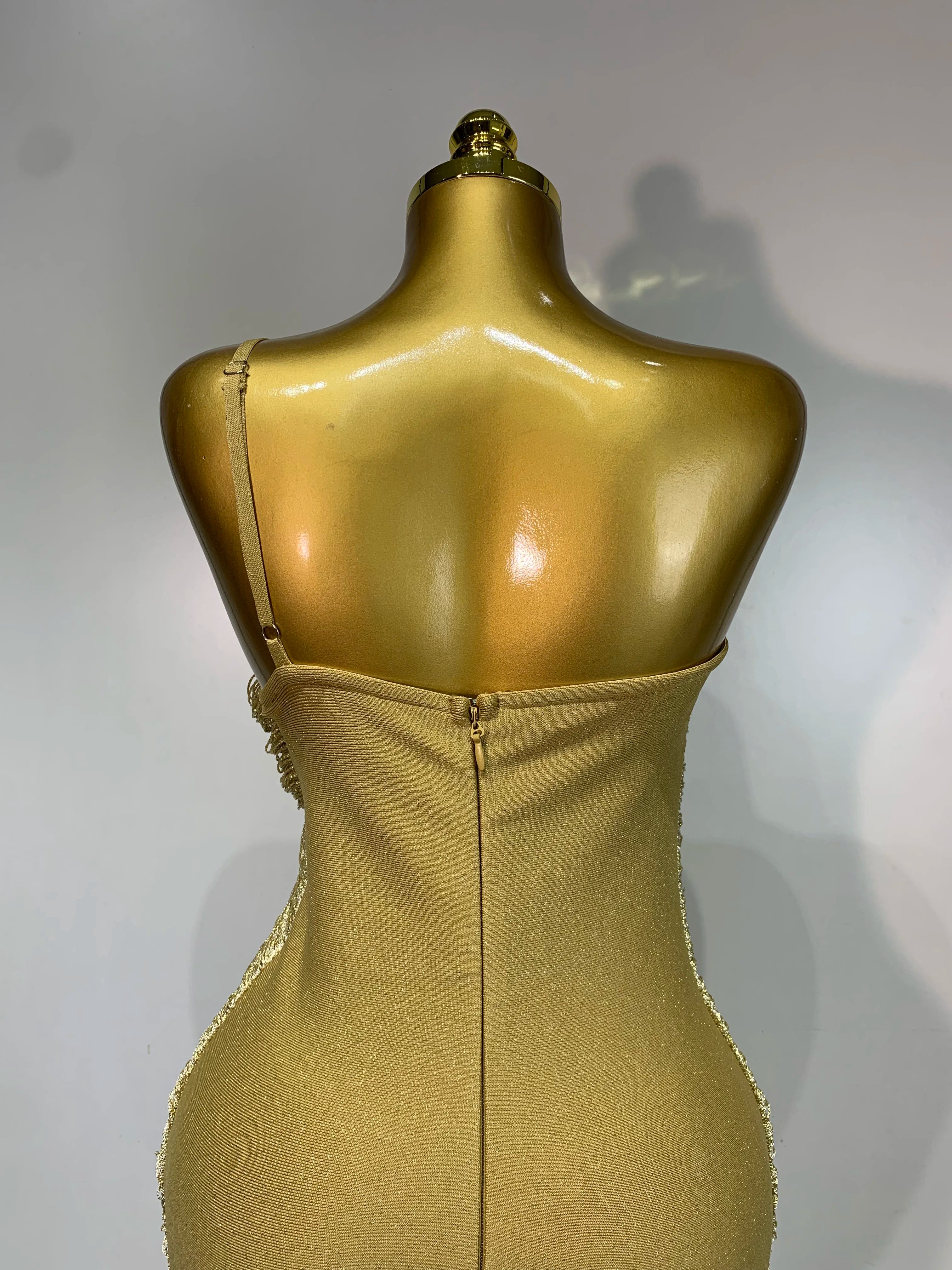 MC Women backless gold bodycon bandage dress with tassel details, designed by MC THE BLACK DIAMOND, showcasing a stylish, fitted silhouette.